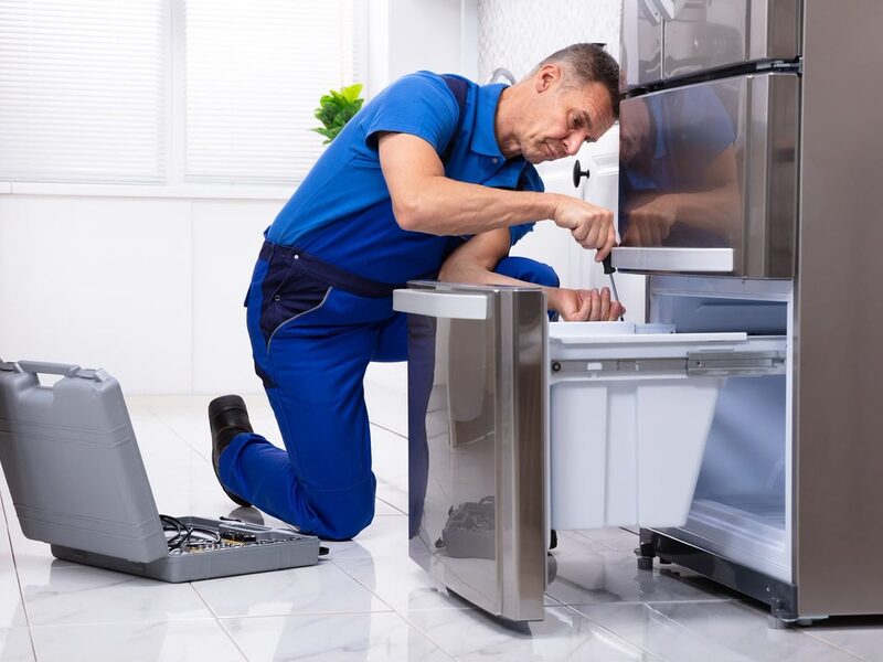 Technician repairing the freezer drawer of a combi fridge-freezer